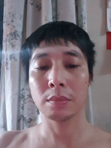 Man Without Shirt Lying Down Looking At Camera GIF