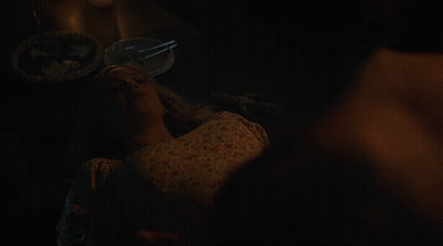 Man Without Shirt Sitting On Woman's Lap In Dark Room GIF