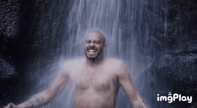 Man Without Shirt Smiling In Front Of Waterfall GIF