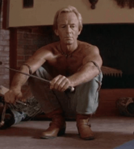 Man Without Shirt Squatting With Sword GIF