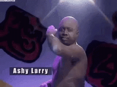 Man Without Shirt Standing In Front Of Ashy Larry Sign GIF