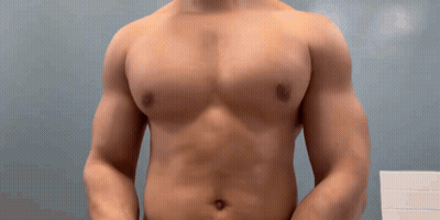 Man Without Shirt Standing In Front Of Blue Wall GIF