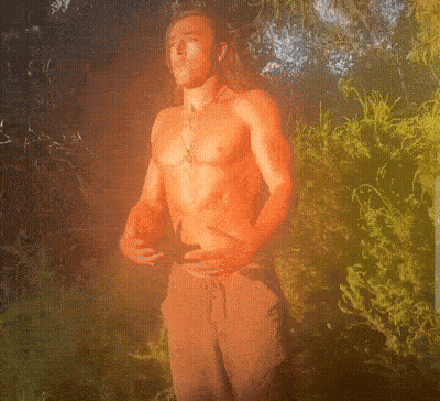 Man Without Shirt Standing In Front Of Trees GIF