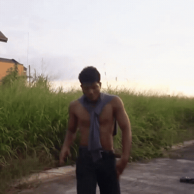Man Without Shirt Standing In Tall Grass GIF