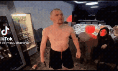 Man Without Shirt Standing With TikTok Logo GIF