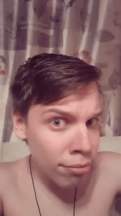 Man Without Shirt Taking Selfie In Front Of Floral Curtain GIF