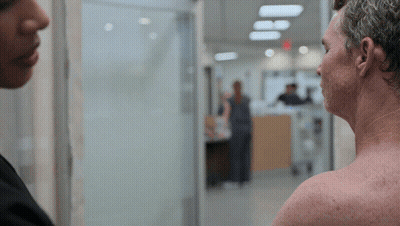 Man Without Shirt Talking To Woman In Hospital Hallway GIF