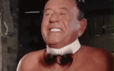 Man Without Shirt Wearing Bow Tie and Necklace