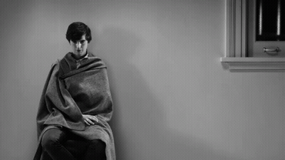 Man Wrapped In Blanket Sitting In Chair By Window GIF