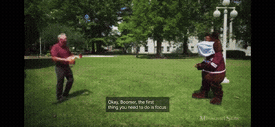 Mascot Costume Talking To Man In Red Shirt GIF