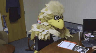 Mascot In Bird Costume Sitting At Desk GIF