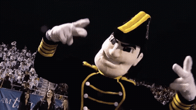 Mascot In Black And Yellow Uniform Pointing At Camera GIF