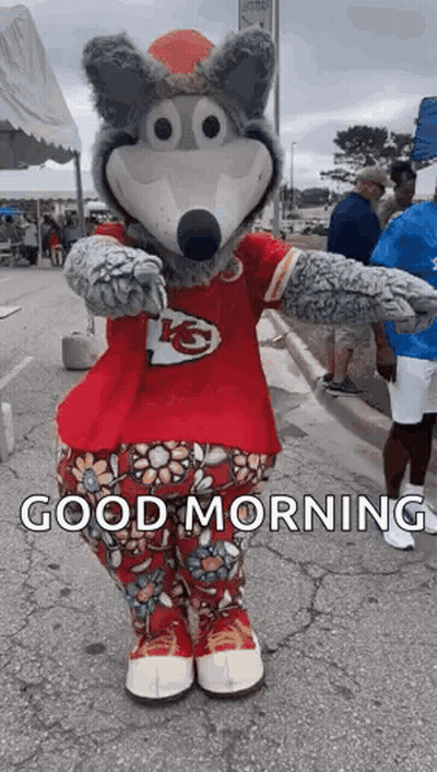 Mascot In Red Shirt And Floral Pants Standing On Road GIF