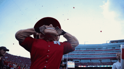 Mascot In Red Shirt With Letter N Looking Up At Sky GIF