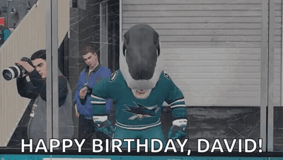 Mascot In Shark Jersey Standing In Front Of Glass Wall GIF