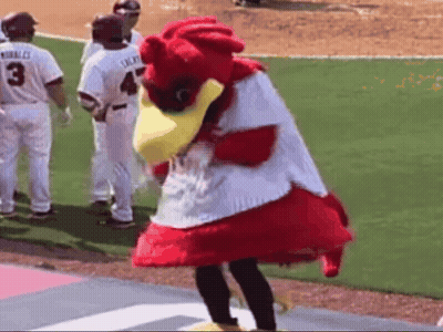 Mascot Standing On Baseball Field With Players Behind GIF