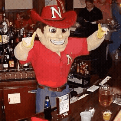 Mascot With Letter N On Hat Standing At Bar GIF