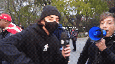 Masked Man Holding Microphone Woman Shouting Into Megaphone GIF