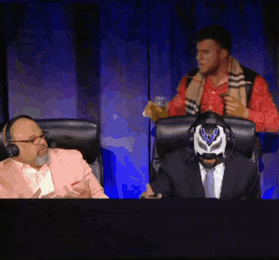 Masked Man In Chair With Suited Man Behind GIF