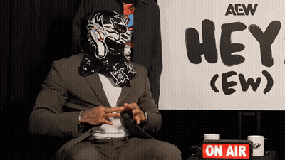 Masked Man In Front Of Sign Saying Hey GIF