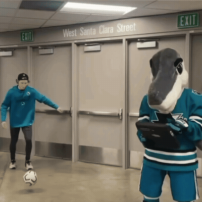 Masked Man Kicking Soccer Ball Beside Mascot With Tablet GIF