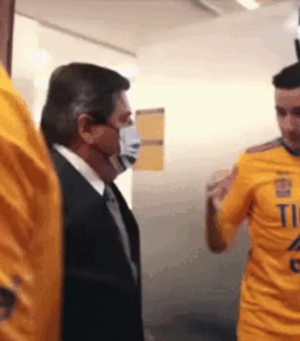 Masked Man Next To Man In Yellow Shirt Number 11 GIF