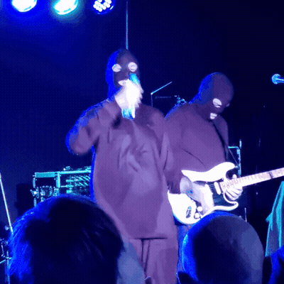 Masked Man Singing Into Microphone Playing Guitar GIF