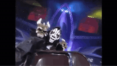 Masked Man Sitting In Stadium With Stage GIF