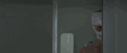 Masked Man Stalking Behind Wall GIF