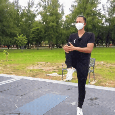Masked Man Stretching Leg In Park GIF
