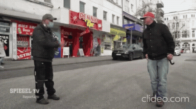 Masked Man Talking To Another In Front Of Penny Store GIF