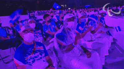 Masked People Sitting In Purple Lit Stadium GIF