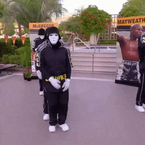 Masked People Standing In Front Of McGregor Sign GIF