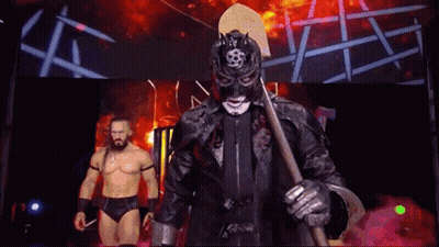Masked Wrestler Holding Axe With Another Wrestler Behind GIF