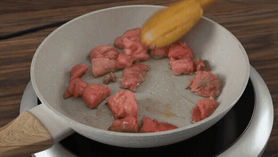 Meat Is Being Cooked In A Pan On A Stove GIF