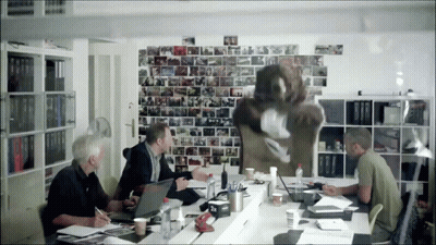 Men At Table With Papers Laptops And Picture Wall GIF