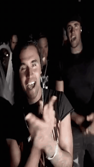 Men Dancing In Dark Room One Smiling And Clapping GIF