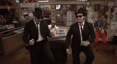 Men Dancing In Front Of Help Wanted Sign GIF
