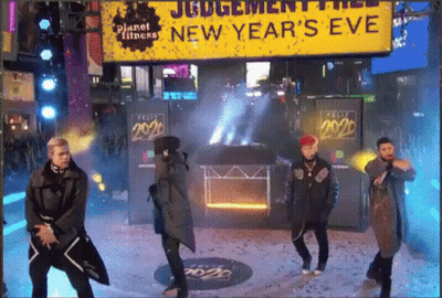 Men Dancing In Front Of New Year's Eve Sign GIF