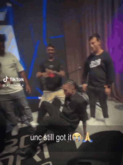 Men Dancing In Front Of TikTok Sign GIF