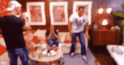 Men Dancing In Living Room While Woman Sits On Couch GIF