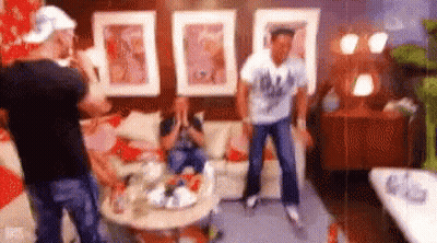 Men Dancing In Living Room While Woman Sits On Couch GIF