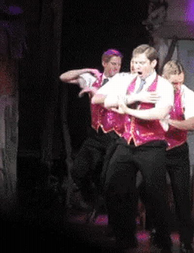 Men Dancing In Red Vests On Stage GIF