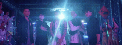 Men Dancing On Stage In Front Of Devil's Building GIF