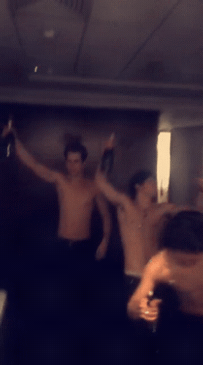 Men Dancing Shirtless in Dark Room