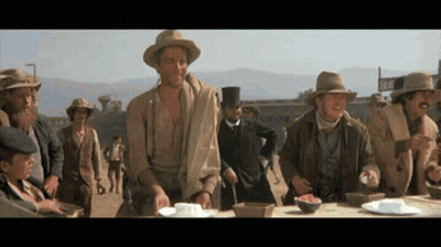 Men Gathered Around Table With Motel Sign GIF