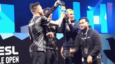 Men Holding Trophy In Front Of ESL Logo GIF