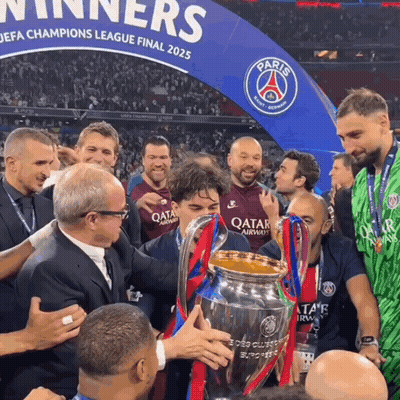 Men Holding Trophy In Front Of Paris Sign GIF