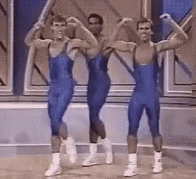 Men In Blue Leotards Flexing And Dancing GIF