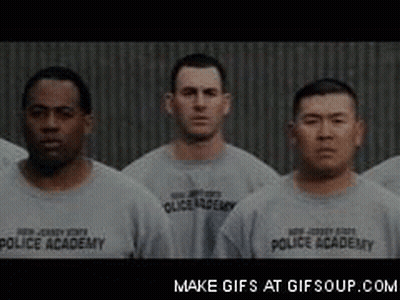 Men in Gray Police Academy Shirts Standing in Line